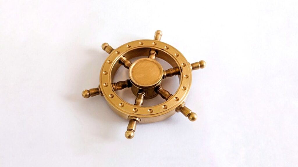 resource requests — A golden ship steering wheel on a white background